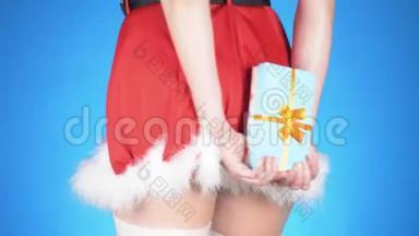 圣诞节假期。 年轻迷人的女人穿着雪少女的服装，带着礼物，在蓝色的背景上跳舞。 特写